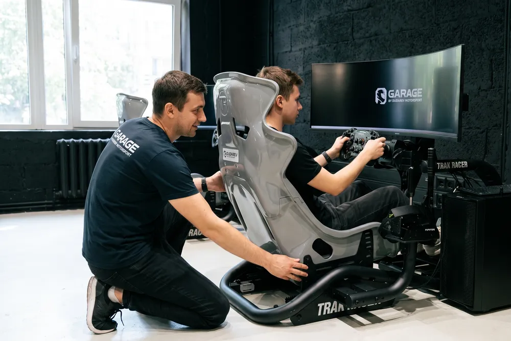 Администратор клуба Garage настраивает ковш и посадку гоночного симулятора под гостя перед стартом